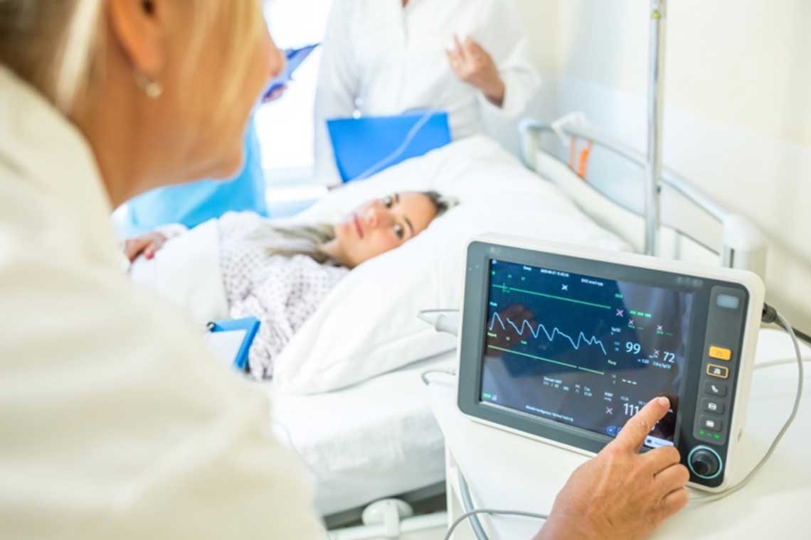 nurse looking at patient heartbeat monitor