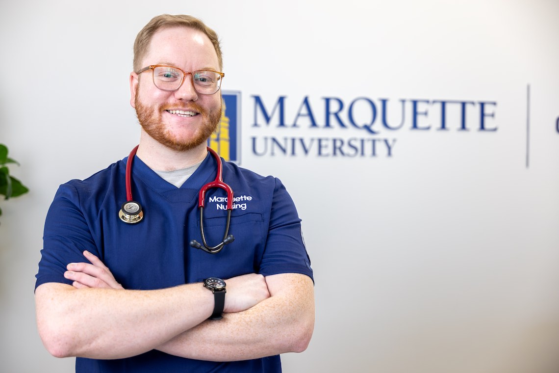 Nursing student standing confidently by sign