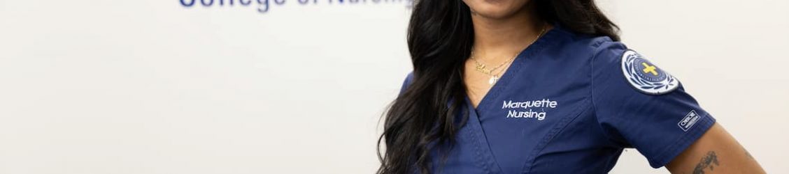 Nursing student posing in front of a wall
