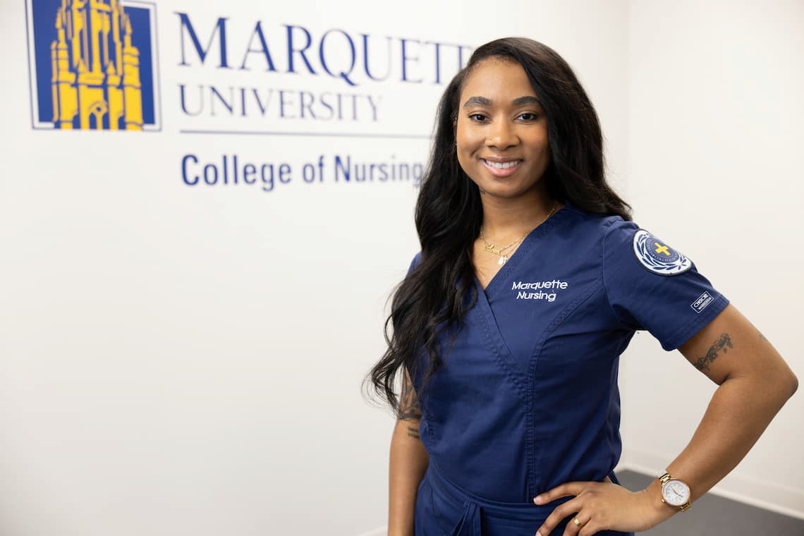 Nursing student posing in front of a wall