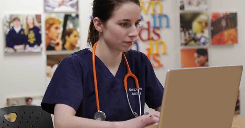 nursing student at desk using laptop