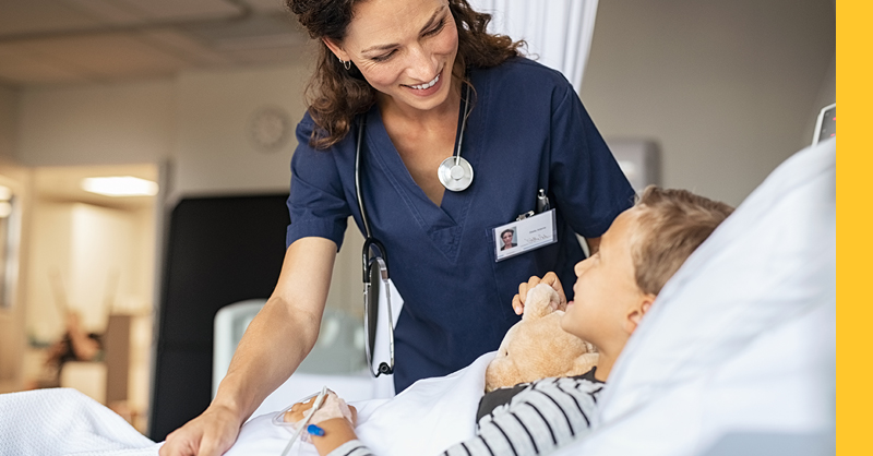 nurse standing at bedside with child patient